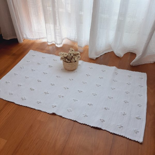 pequeno tapete branco tricotado à mão